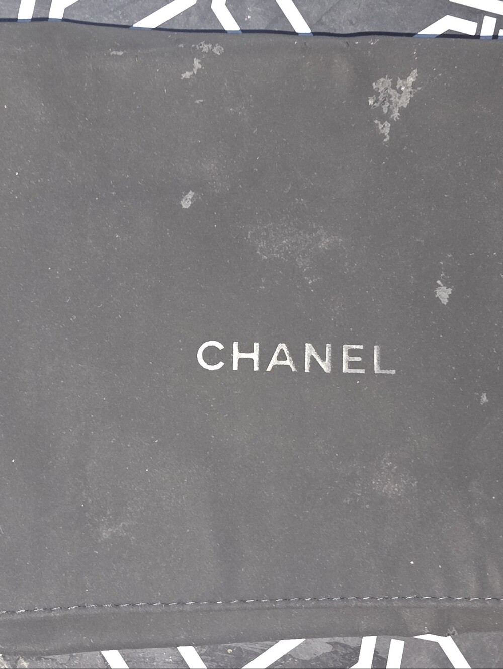 CHANEL flap dust bag in black with white CHANEL logo.